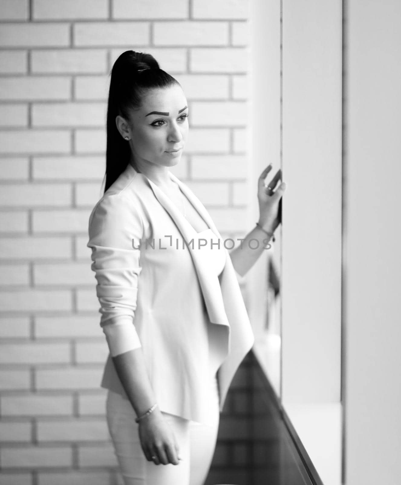 modern business woman standing near the window in the corridor of the office