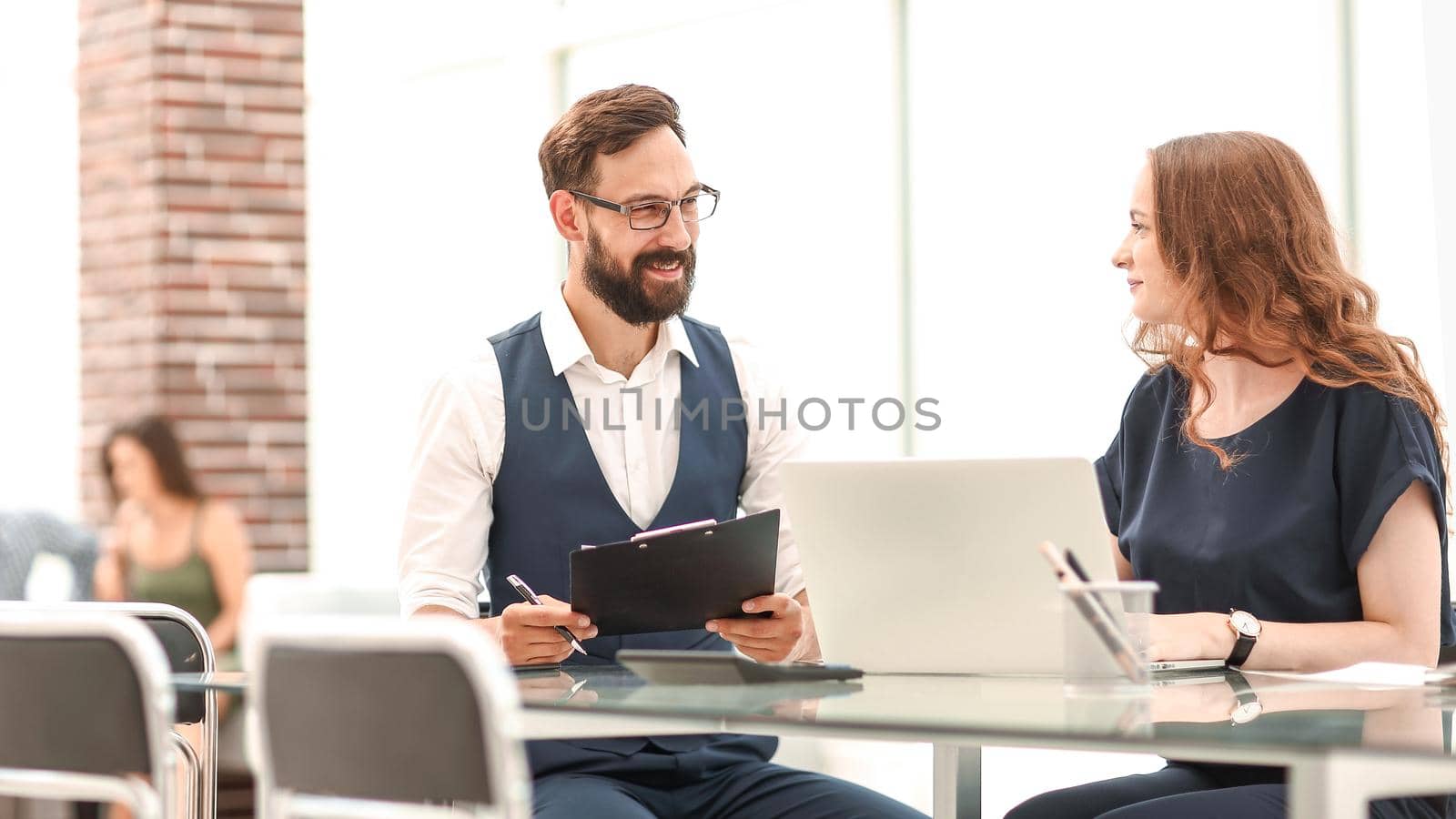 two employees discussing new ideas while sitting at the Desk.photo with copy space