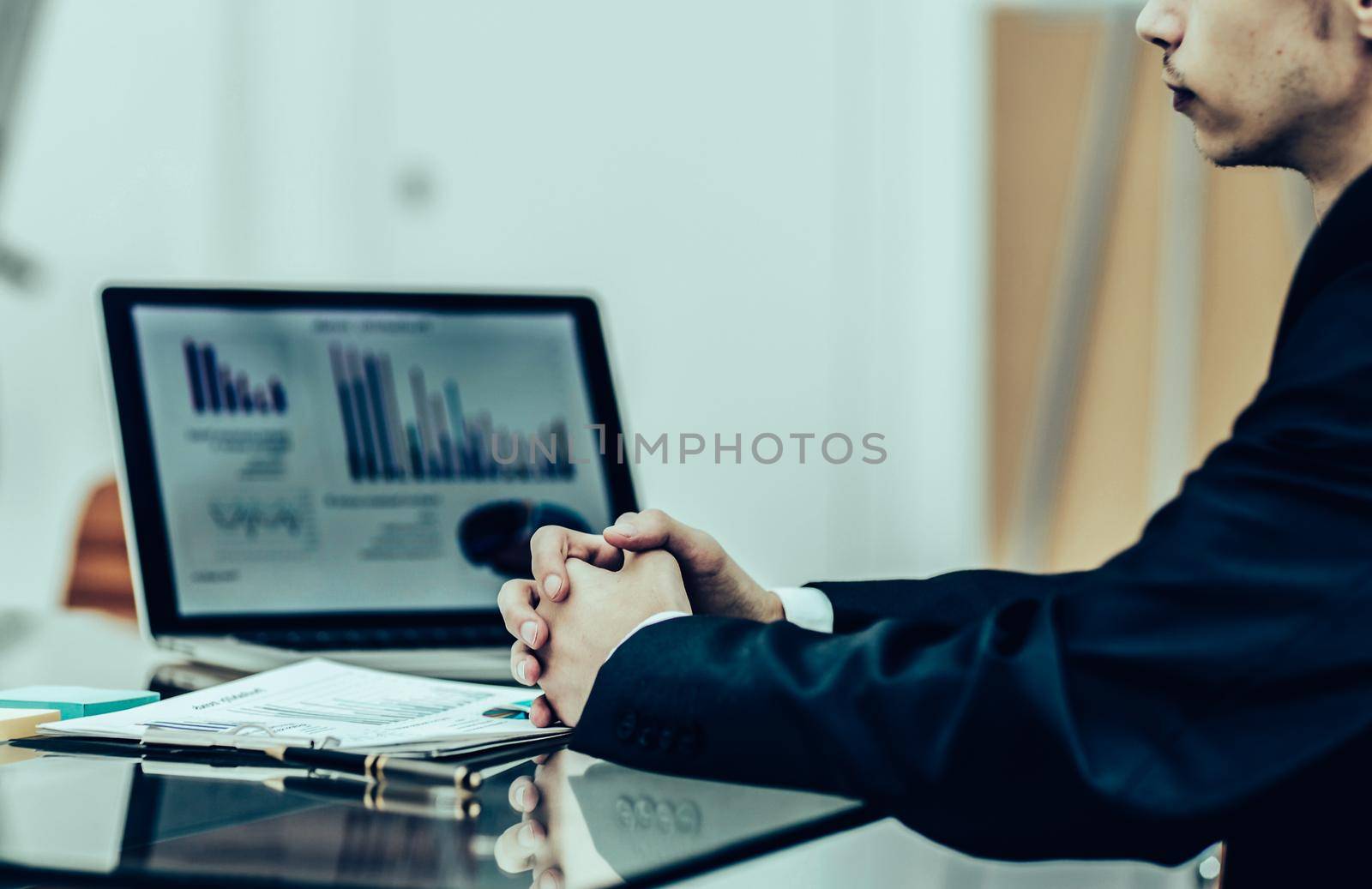 closeup of a Manager of the company sitting in front of the open laptop and working with financial information