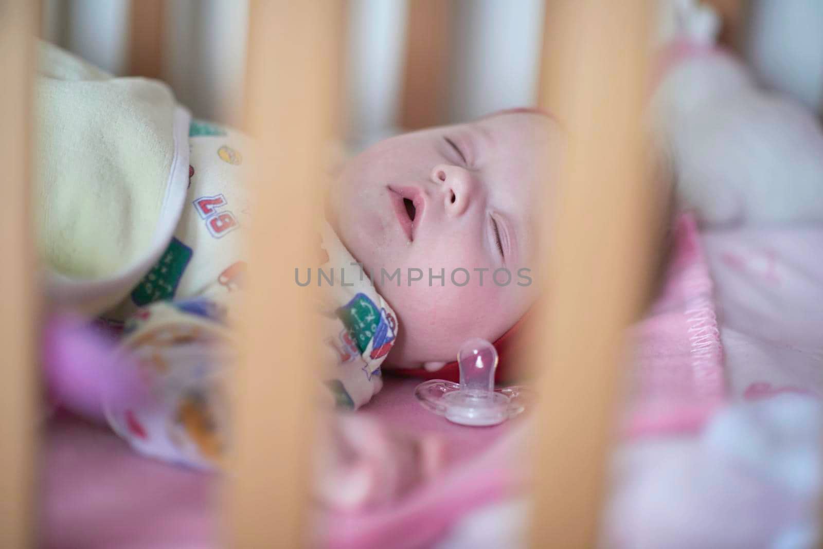 newborn baby girl sleeping in bed at home