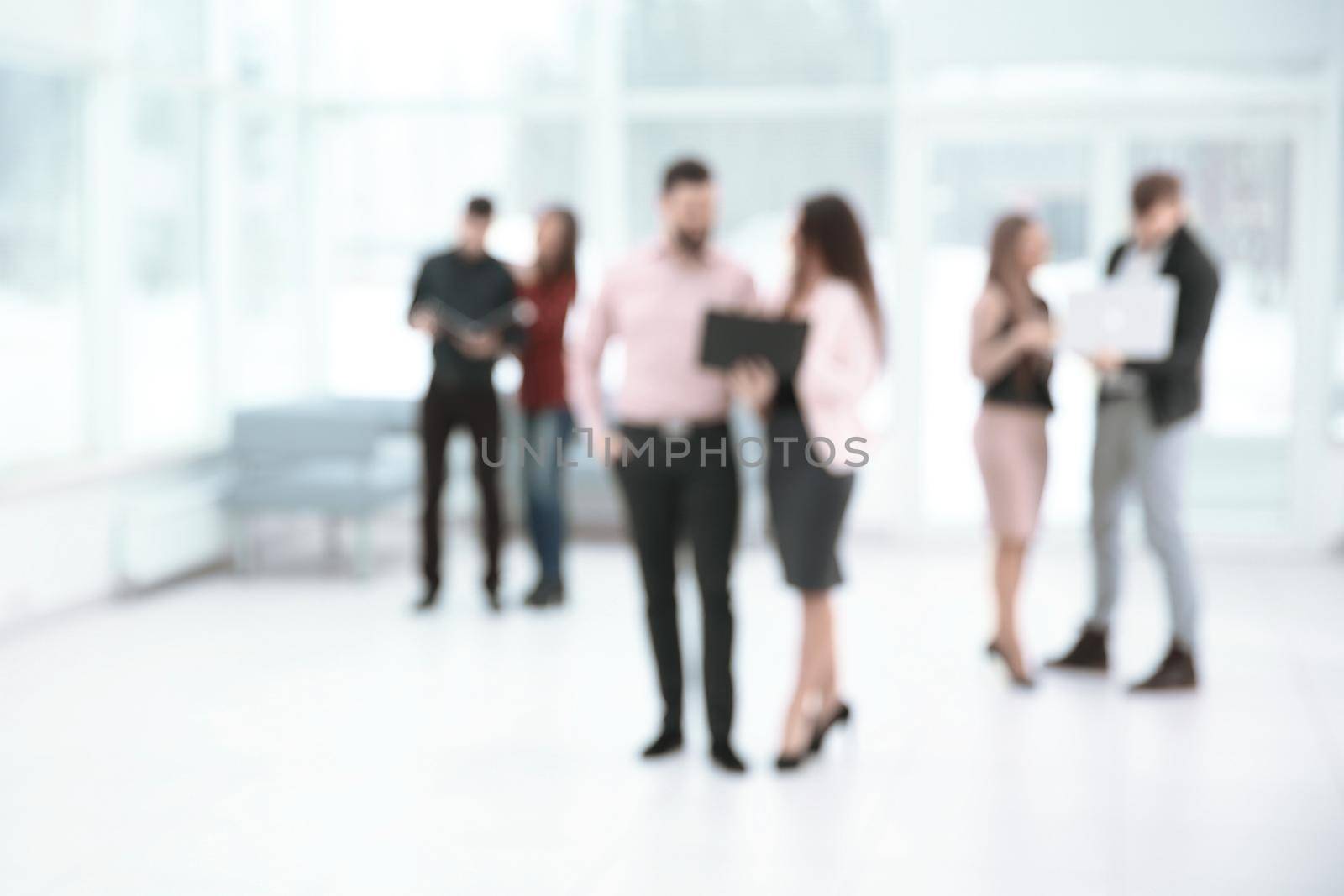blurred image of a group of business people talking in the office lobby. business background.