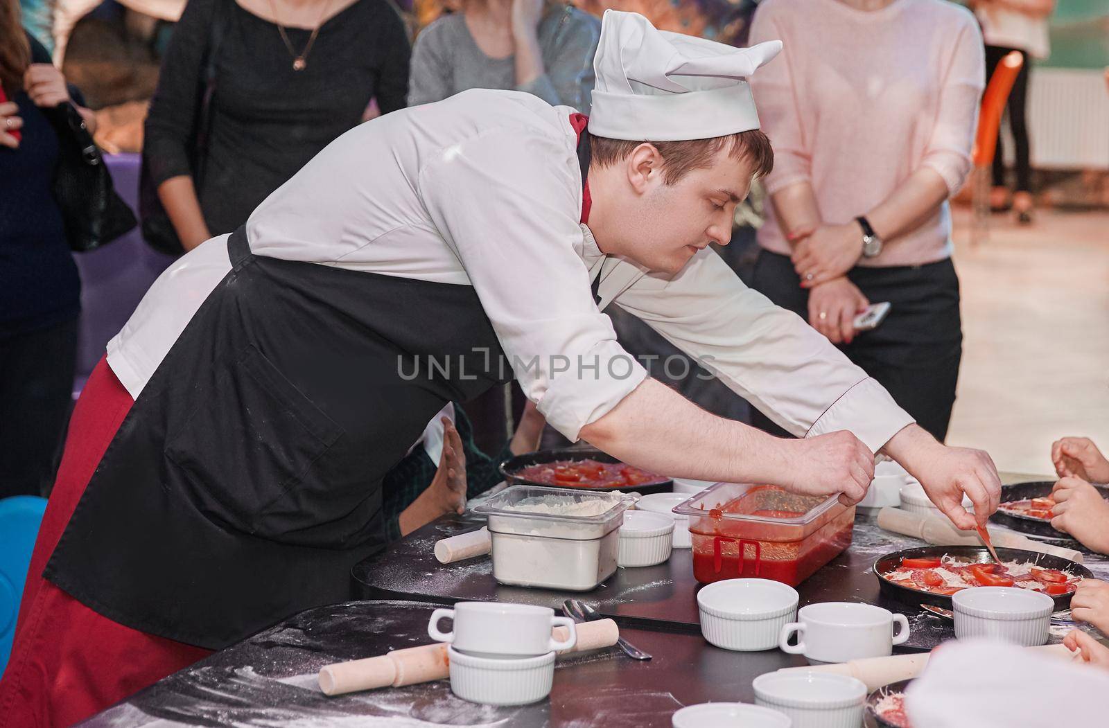 chef prepares pizza in a children's cafe. the concept of skill