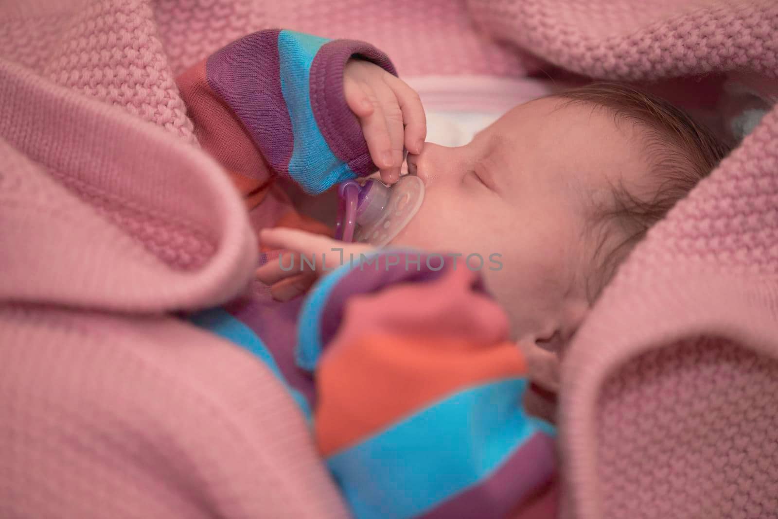 One month newborn baby in bed. Close up portrait of sleeping cute little girl