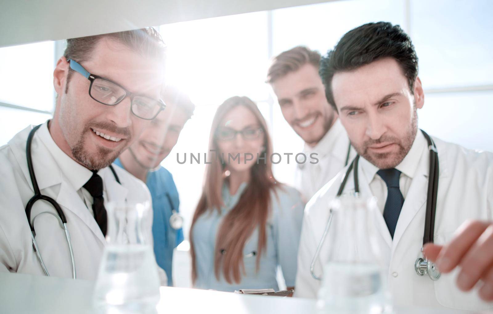 doctor in front of team, looking at camera with medical team in background