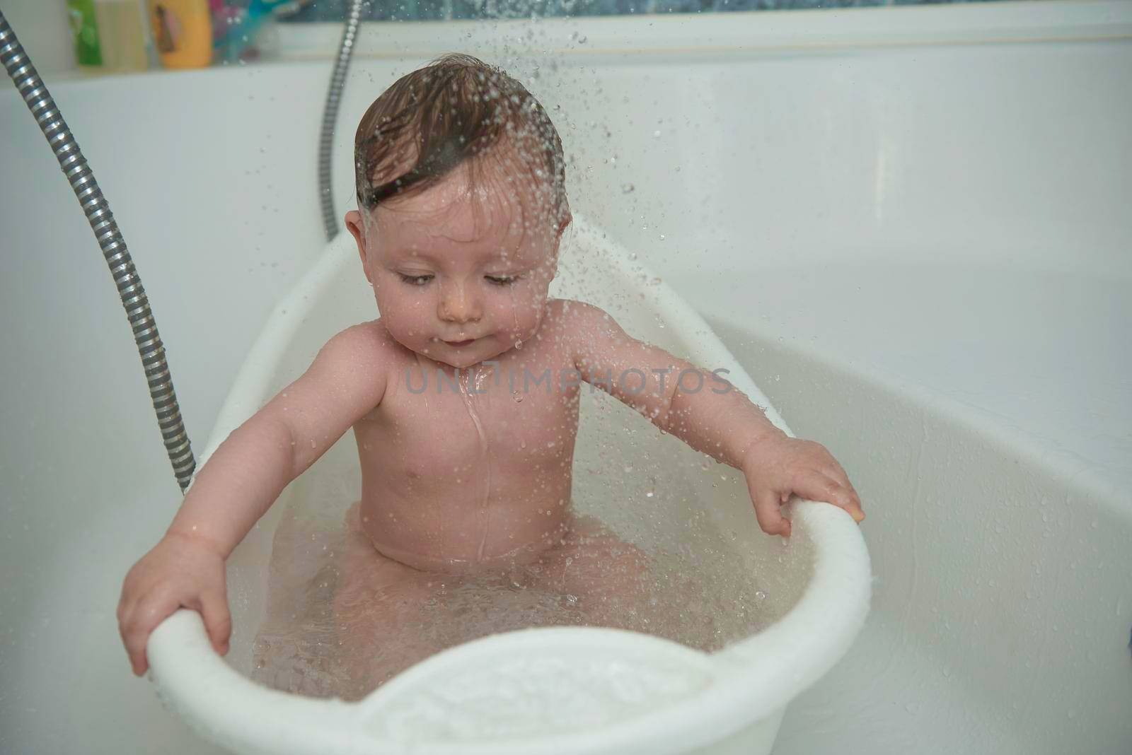 Mother is bathing happy little  baby girl taking a bath