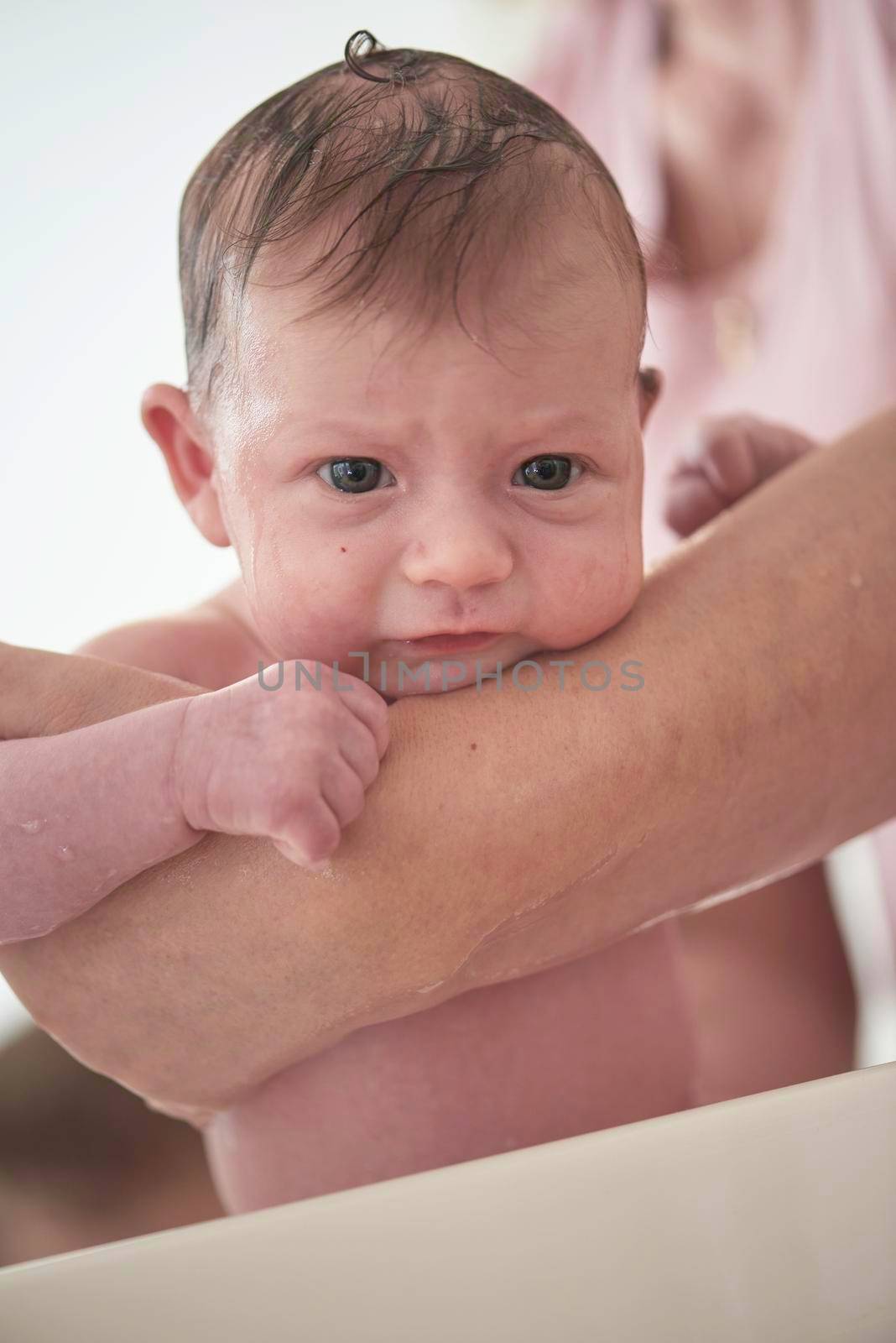 Mother is bathing Newborn baby girl taking a bath