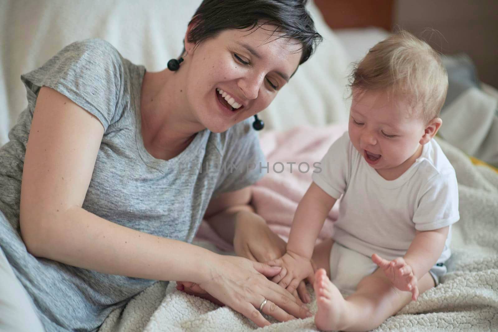 mother is playing with newborn baby at home