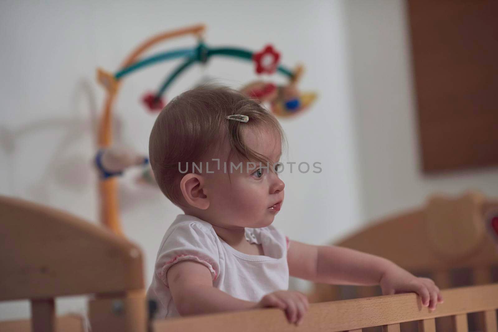 cute  little one year old baby playing with toys in bed while making first steps and learnig to walk