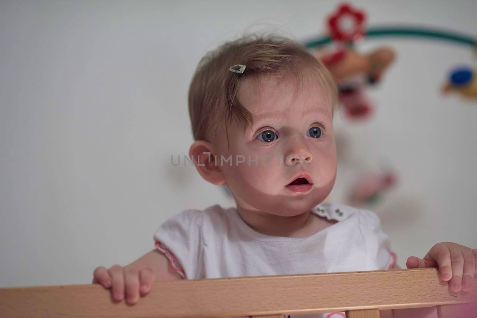 cute  little one year old baby playing with toys in bed while making first steps and learnig to walk