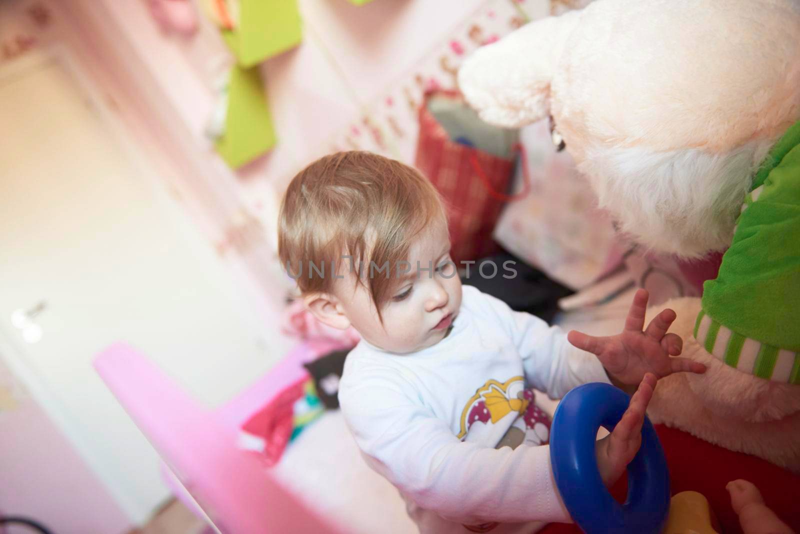 cute  little one year old baby playing  with toys at home while making first steps and learnig to walk