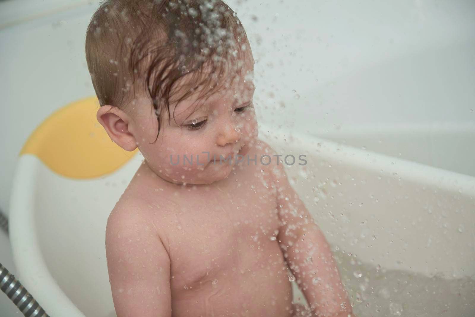 Mother is bathing happy little  baby girl taking a bath