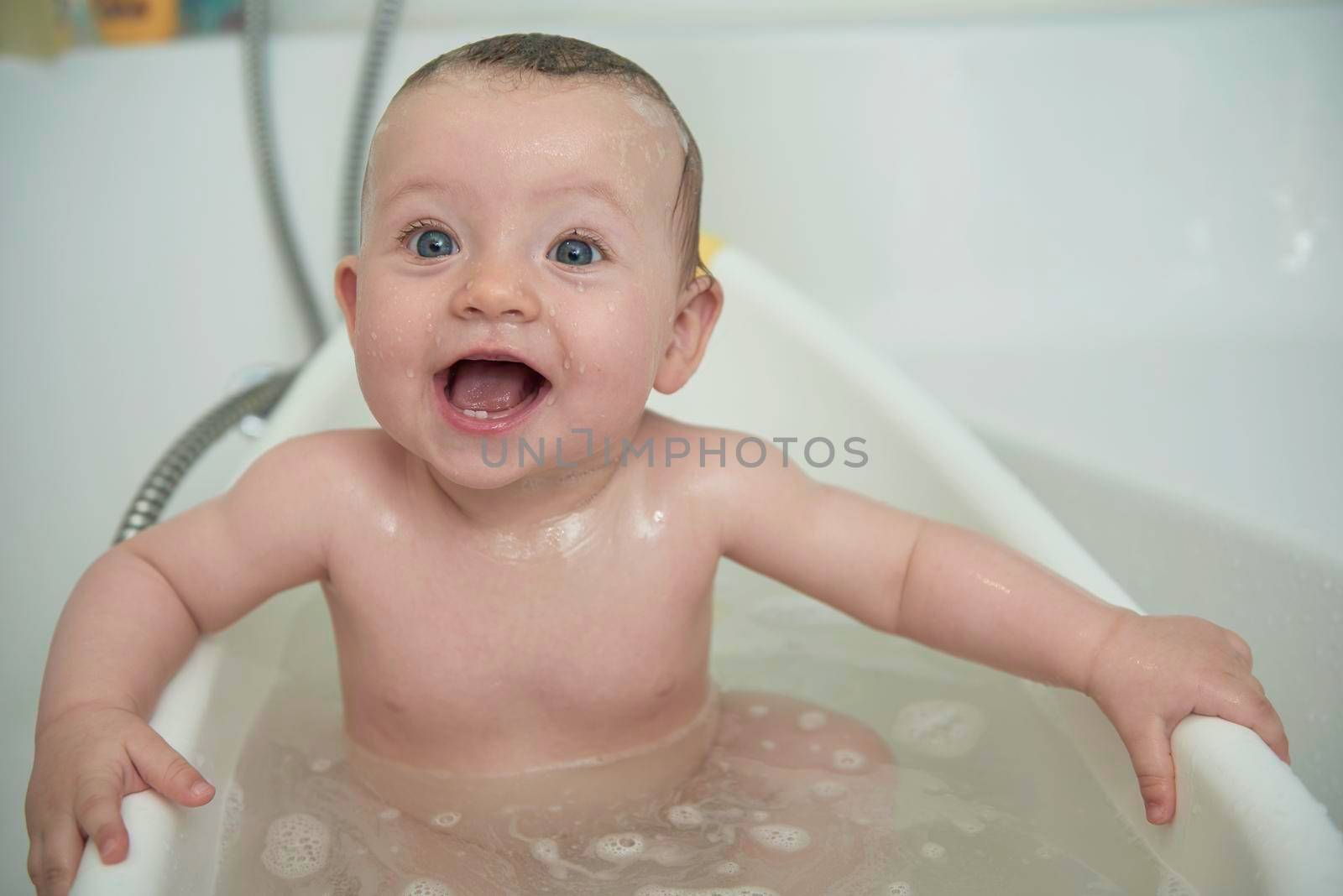 Mother is bathing happy little  baby girl taking a bath