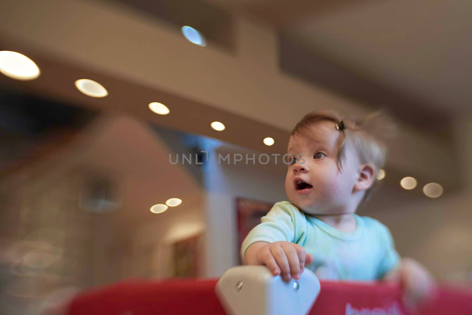 cute  little baby playing with toys in mobile bed making first steps and learnig to stand  and walk