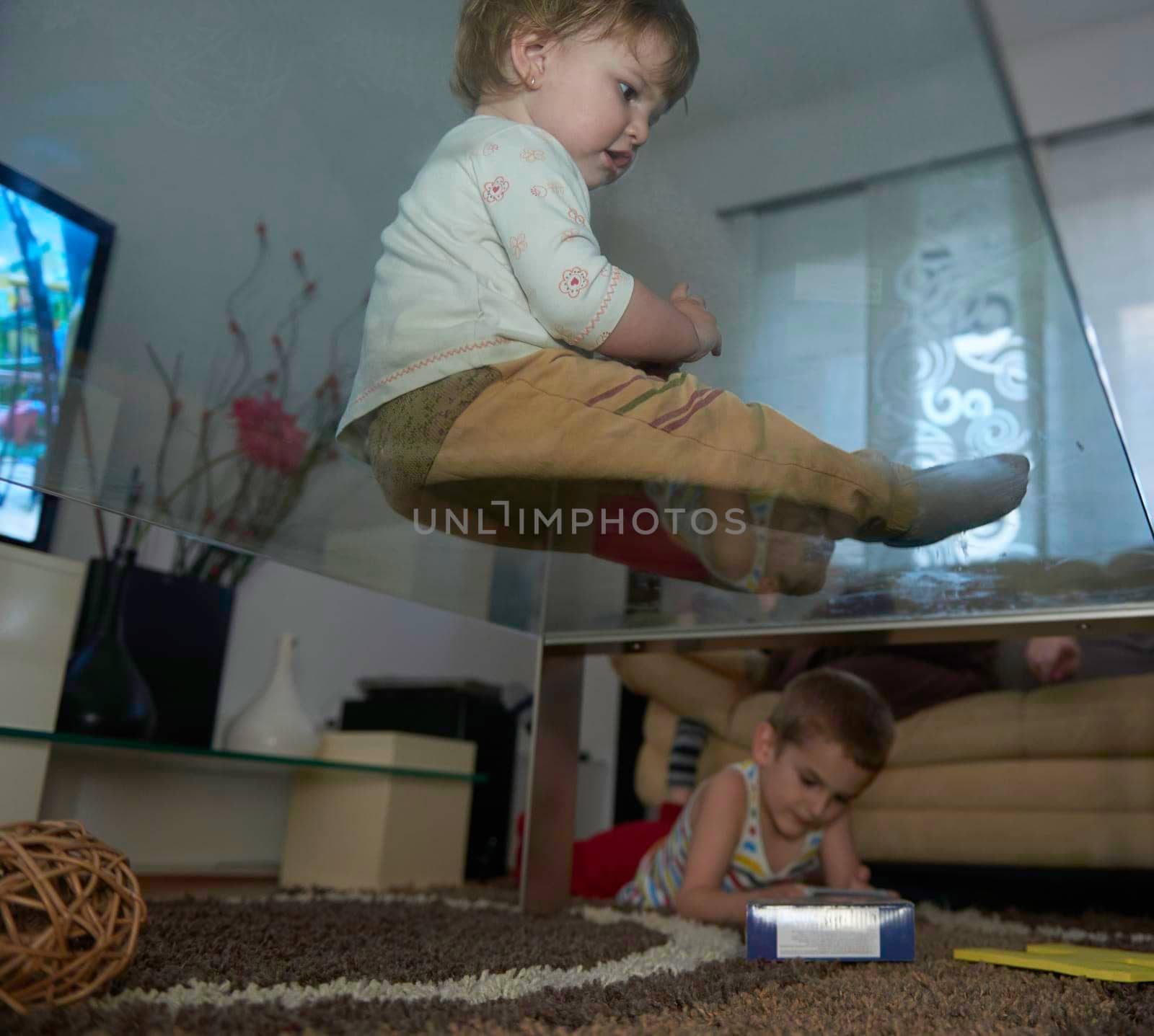 Little child playing at home with baby sister