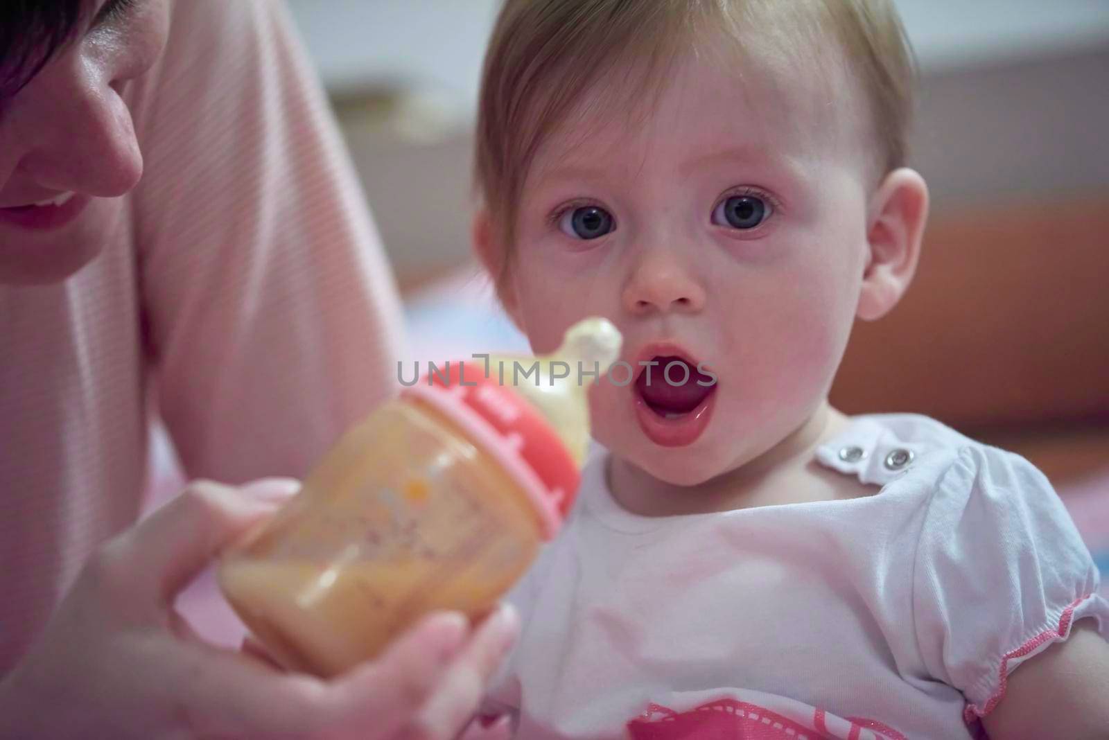 little baby drinking fresh juice  from bottle