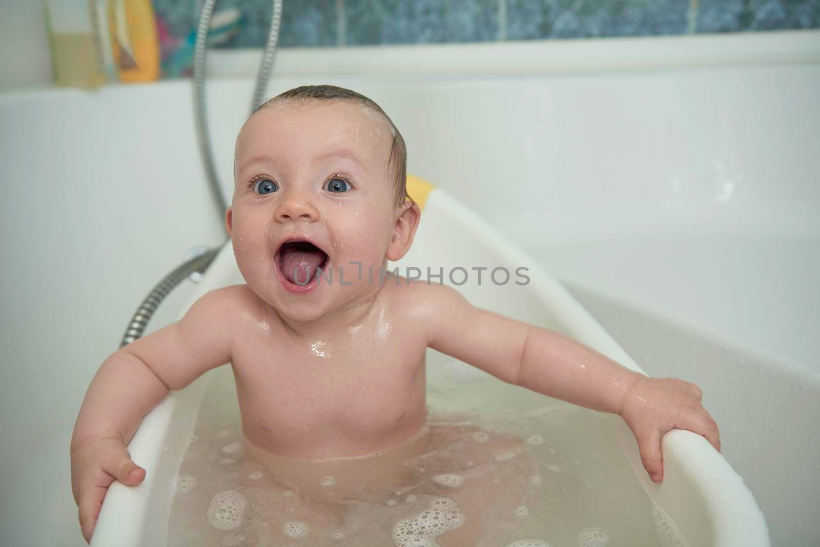 Mother is bathing happy little  baby girl taking a bath