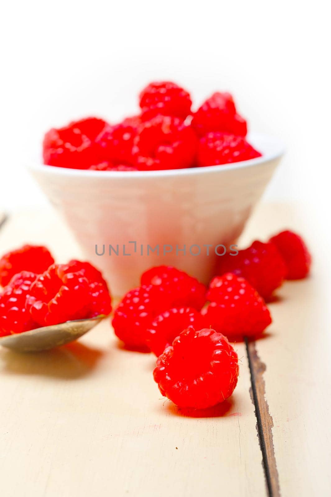 bunch of fresh raspberry on a bowl and white table by keko64