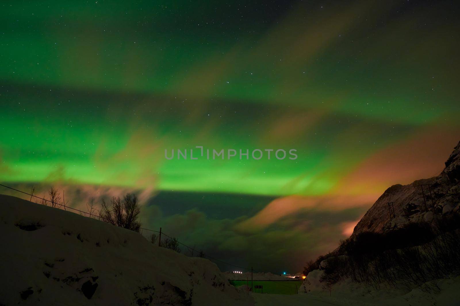 Aurora borealis Green northern lights above mountains on the Lofoten islands, Norway. Night sky with polar lights. Night winter landscape with aurora.