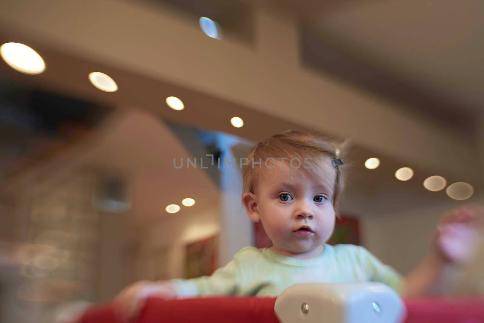 cute  little baby playing with toys in mobile bed making first steps and learnig to stand  and walk