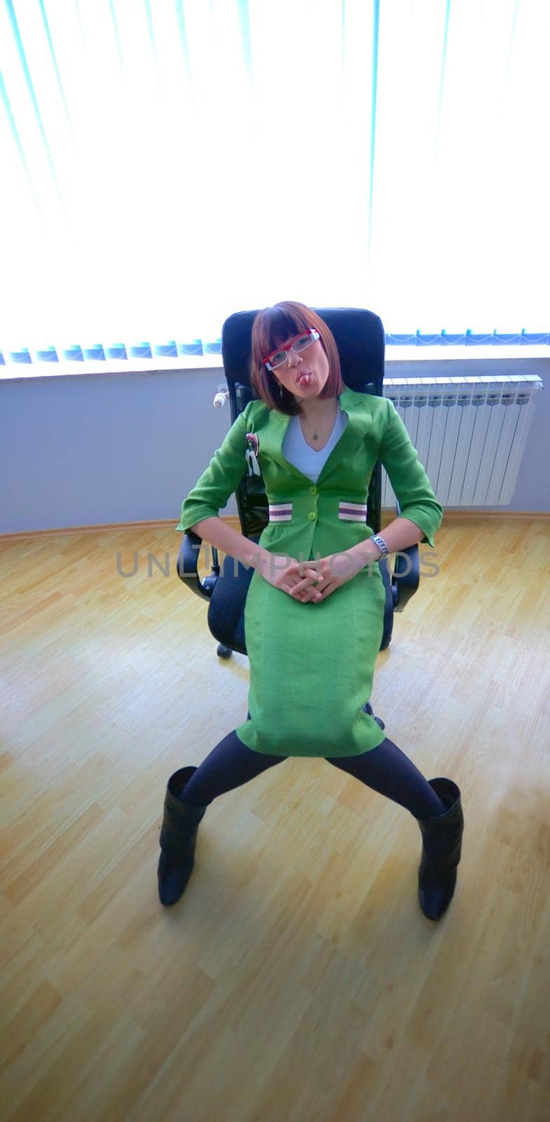 Businesswoman in green suit seating on office chair by dotshock