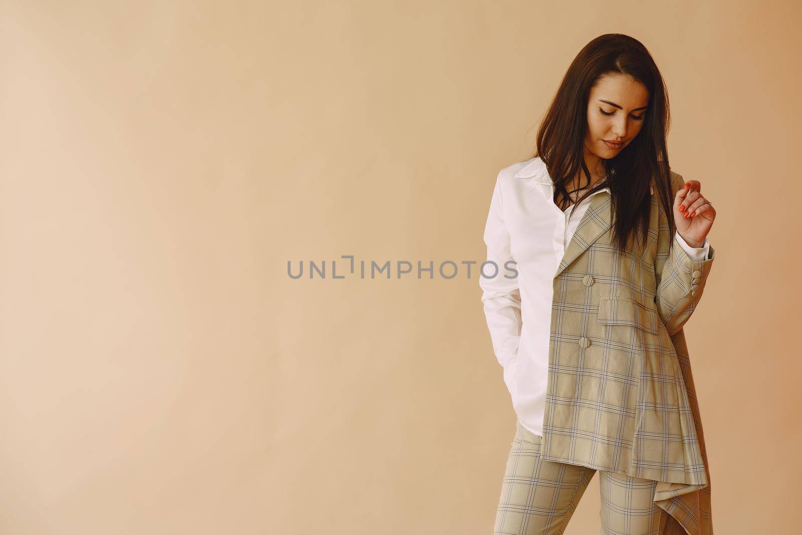 Beautiful girl in a studio. Stylish girl on a brown background. Lady in a jacket.