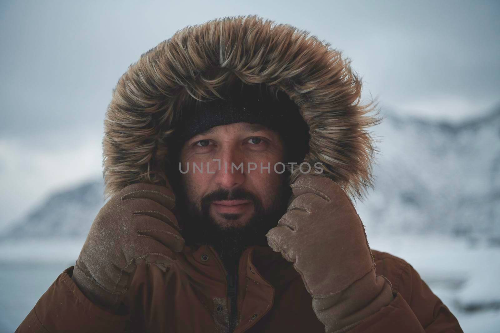 man at winter in stormy weather wearing warm  fur jacket by dotshock