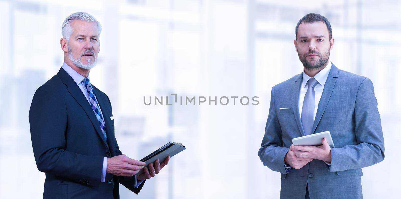 Portrait of two colleague businessmans using tablet in front of the modern IT company