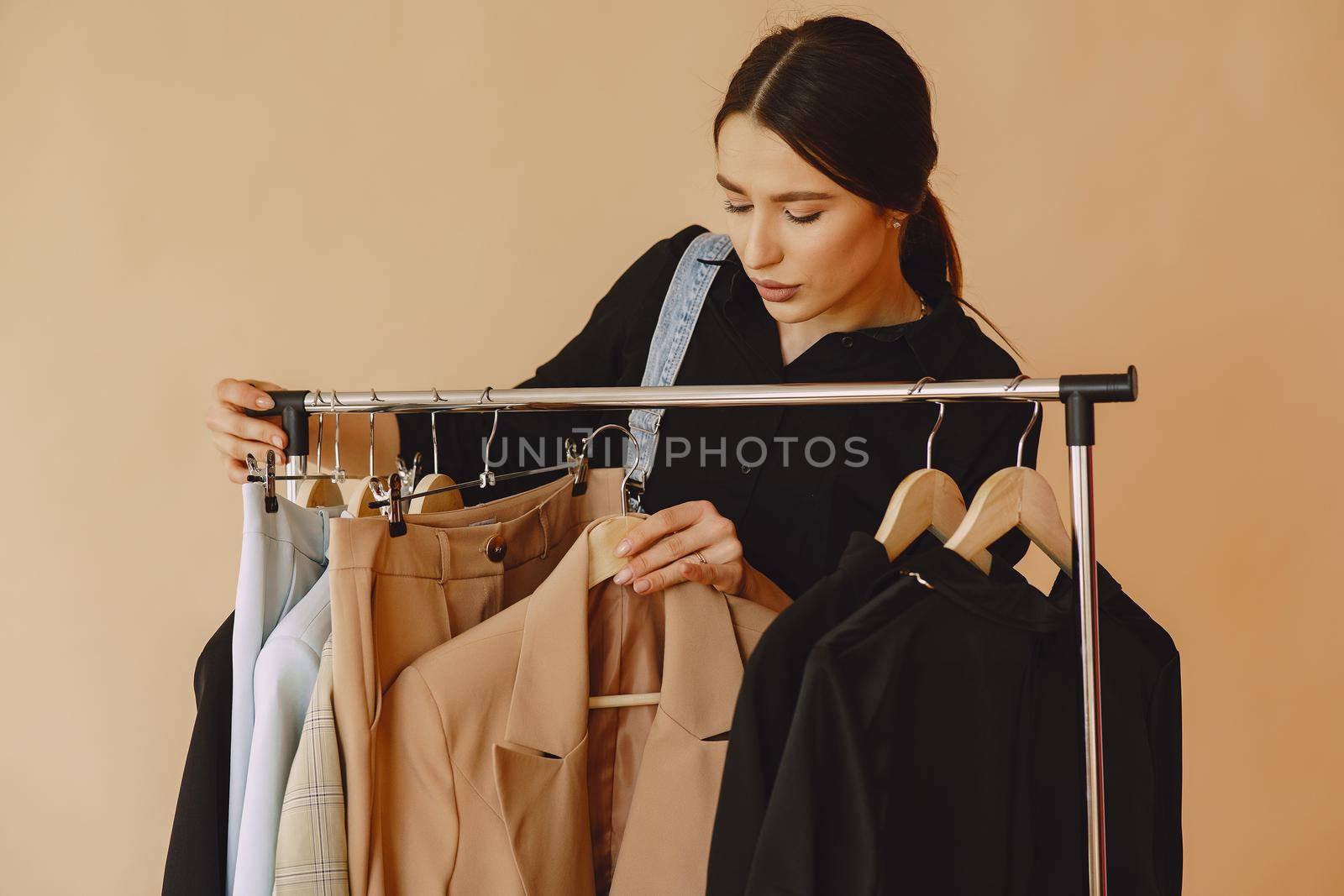 Woman on a brown background. Lady with clothes on a hanger.