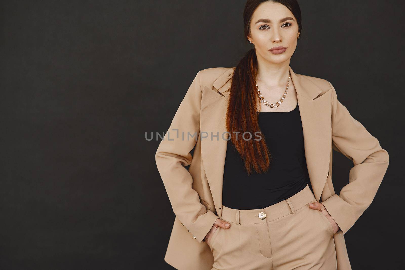 Beautiful girl in a studio. Stylish girl on a black background. Lady in a jacket.