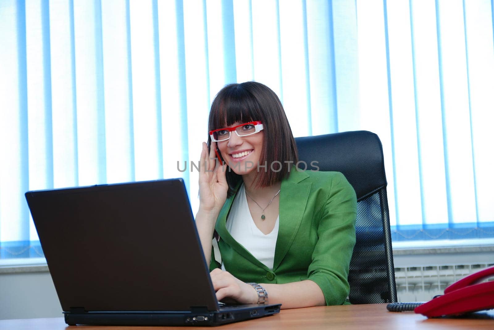 .young businesswoman working on a laptop computer in the office. by dotshock