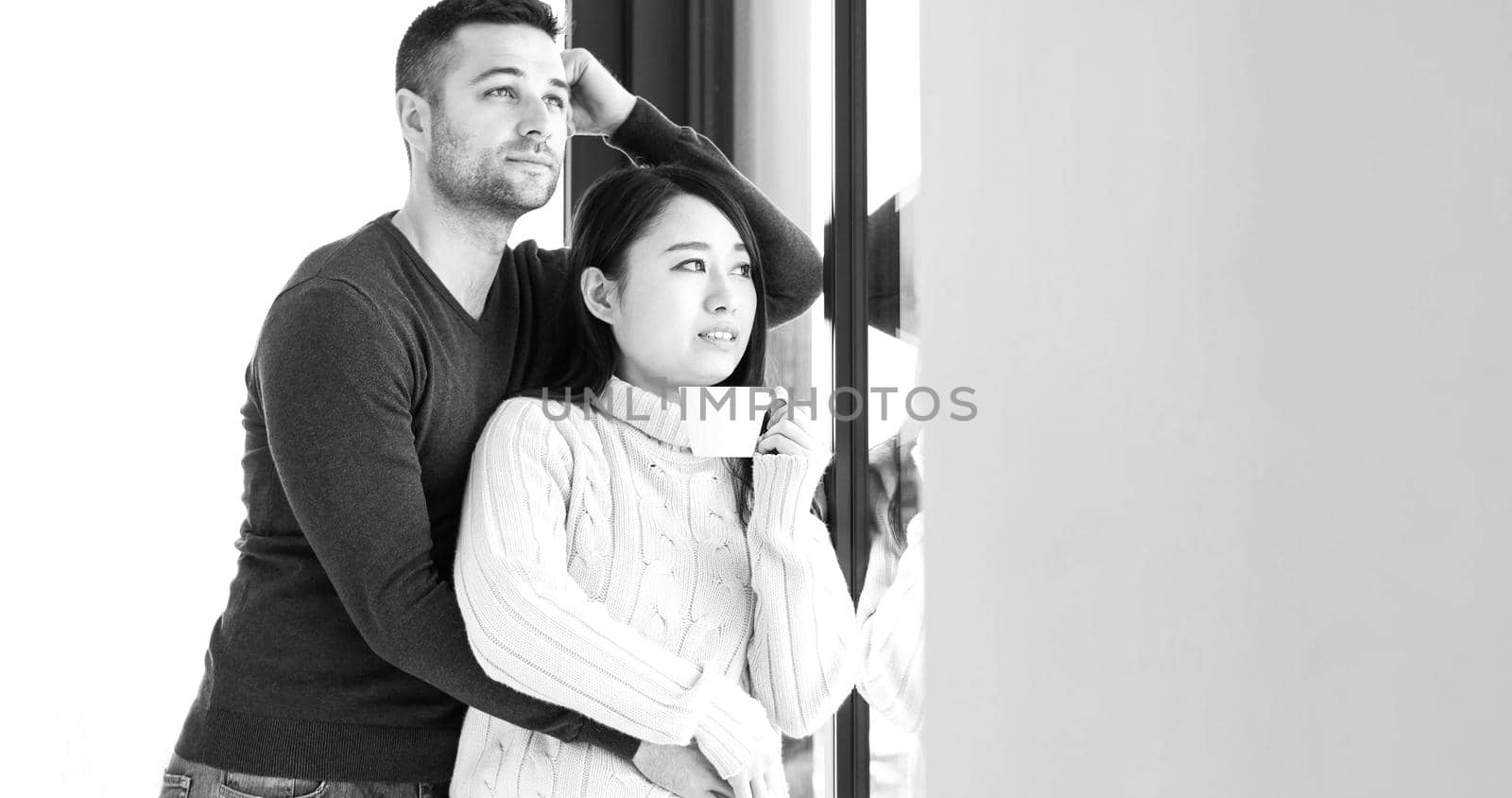 multiethnic couple relaxing at modern home indoors by dotshock