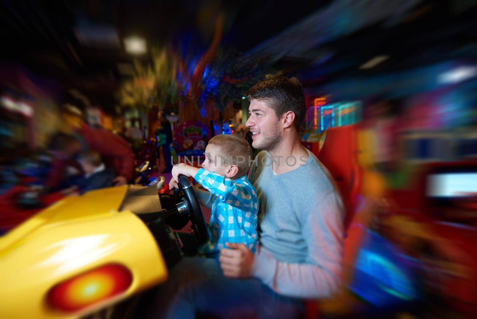 father and son playing game in playground by dotshock