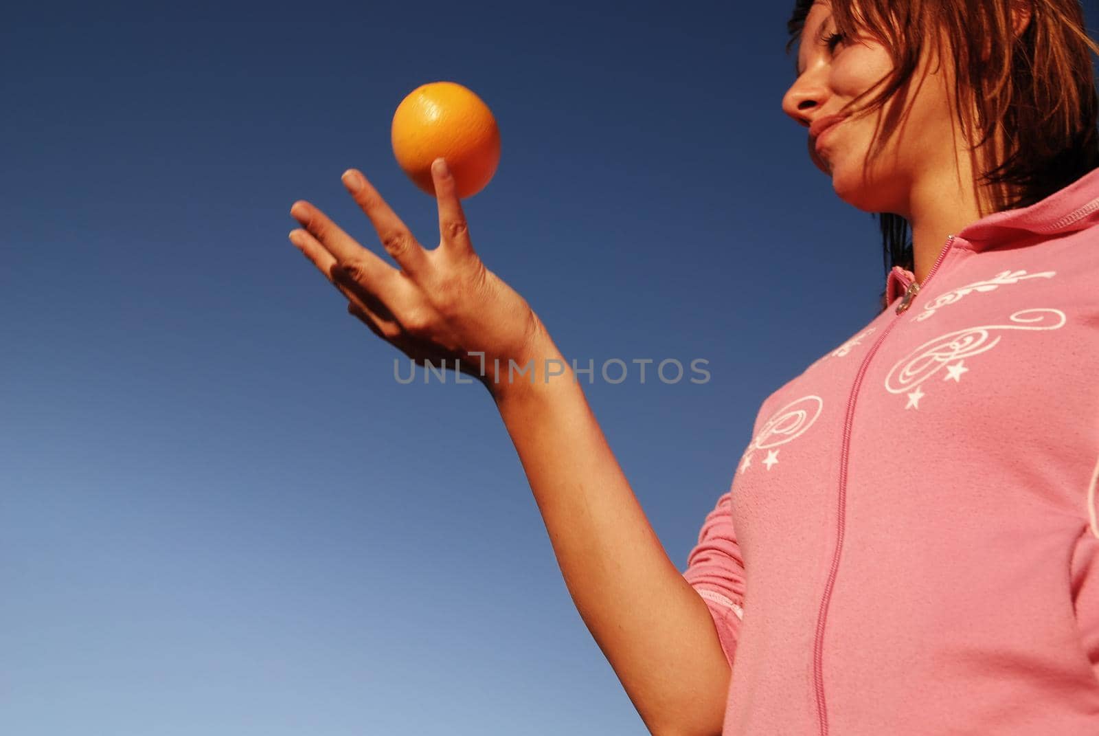 beautyful girl throwing orange in air by dotshock