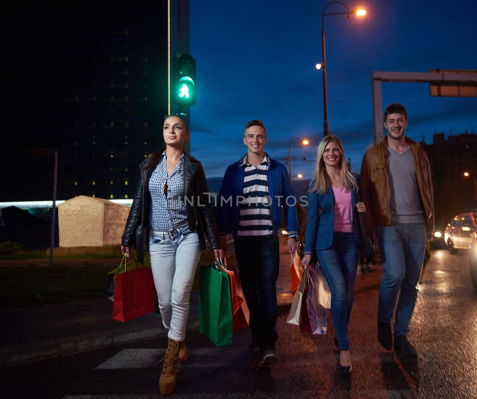 Group Of Friends Enjoying Shopping Trip Together
group of happy young frineds enjoying shopping night and walking on steet on night in with mall in background