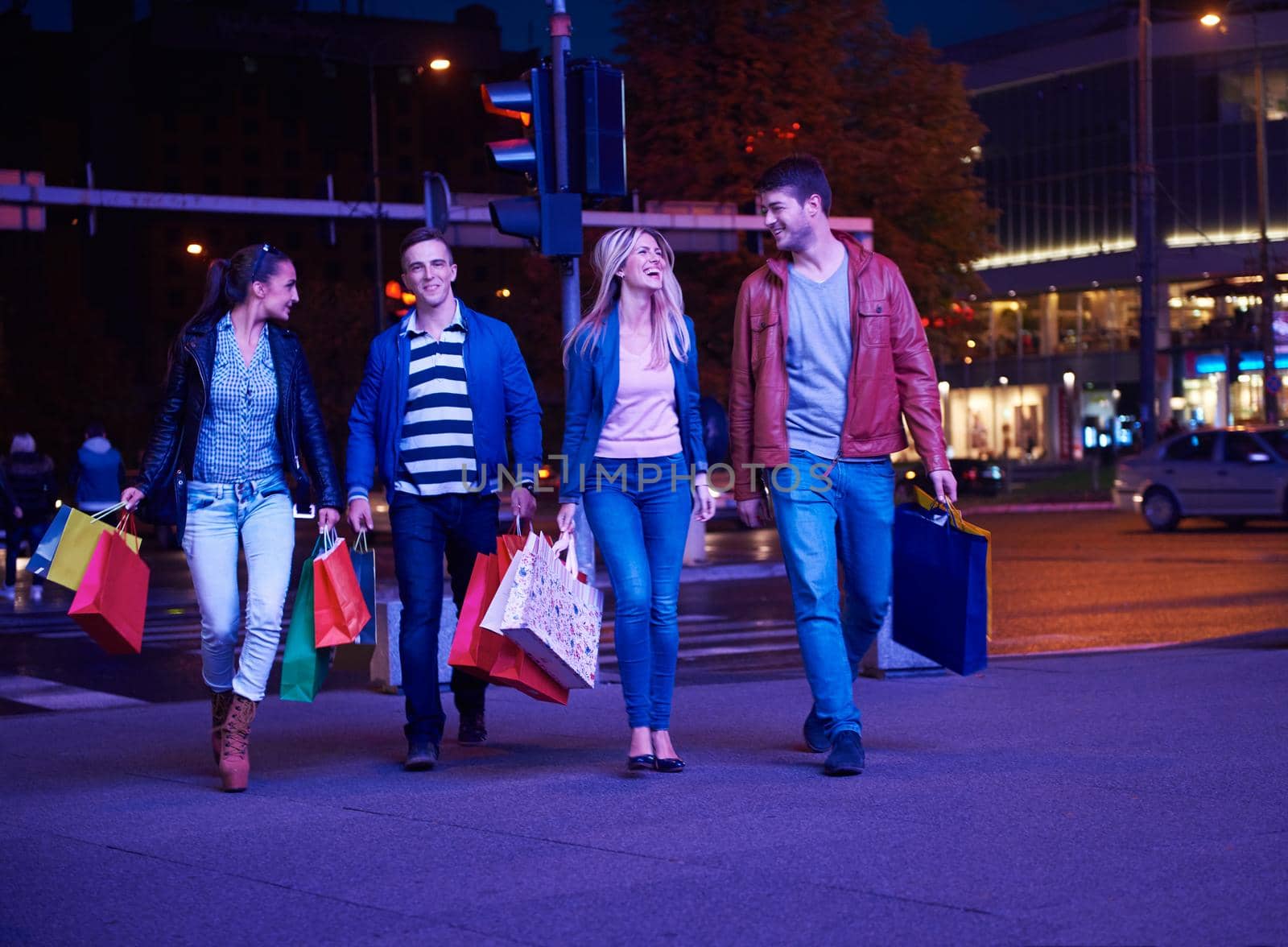 Group Of Friends Enjoying Shopping Trip Together
group of happy young frineds enjoying shopping night and walking on steet on night in with mall in background