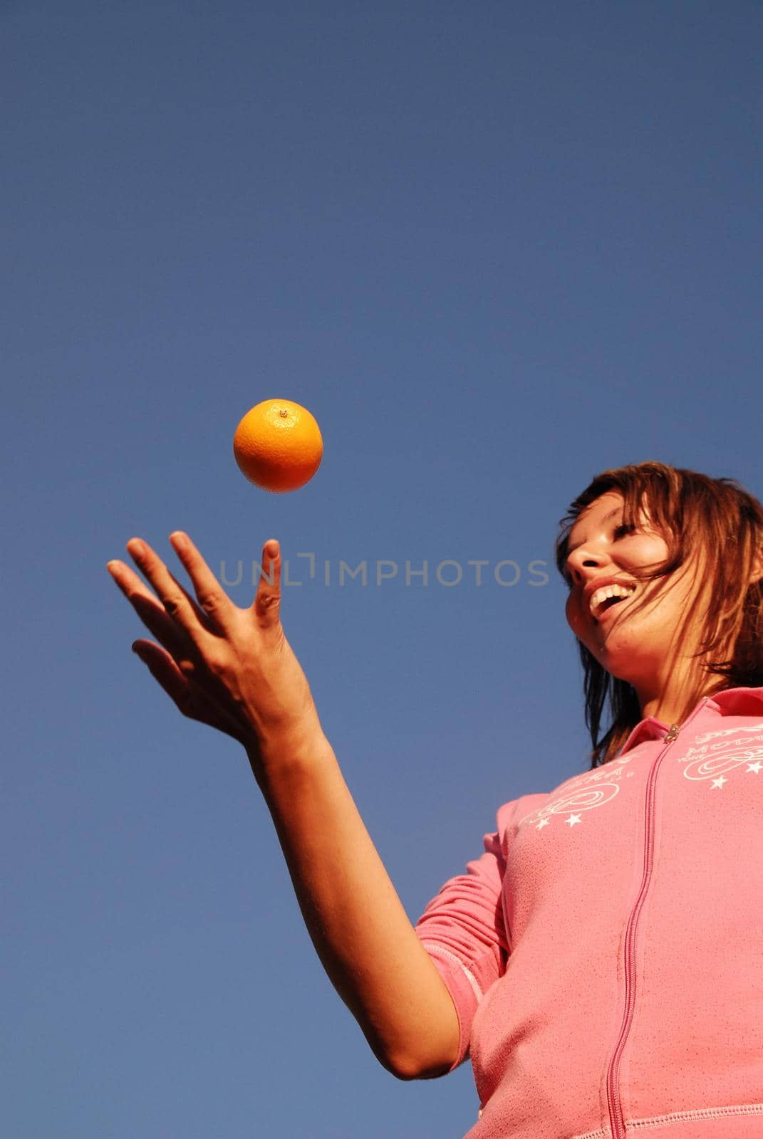 female hand balancing iorange in air by dotshock