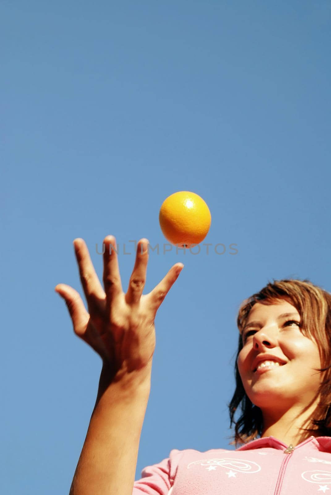 beautyful girl throwing orange in air by dotshock