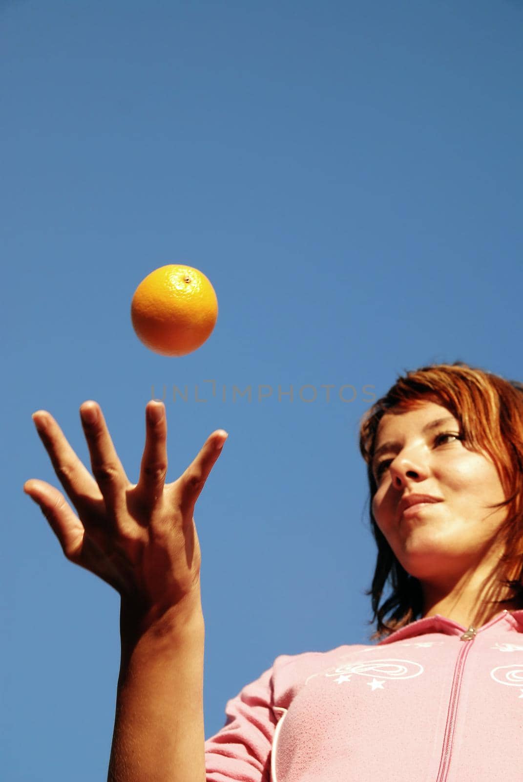 beautyful girl throwing orange in air by dotshock