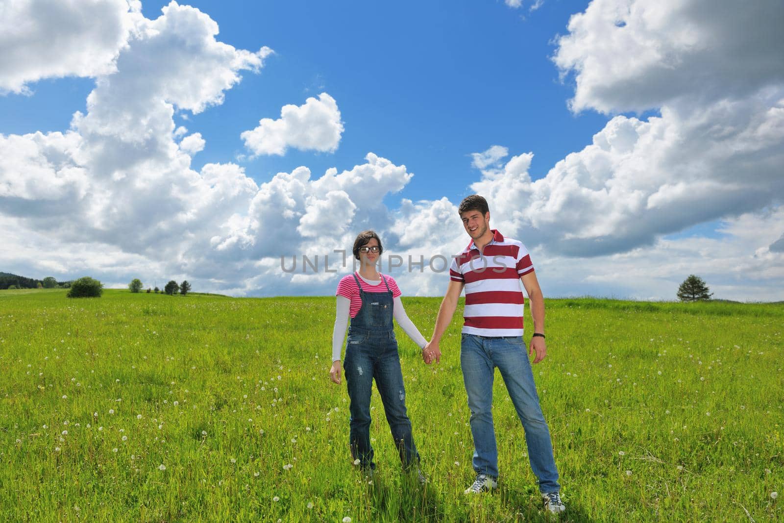 Portrait of romantic young couple in love  smiling together outdoor in nature with blue sky in background