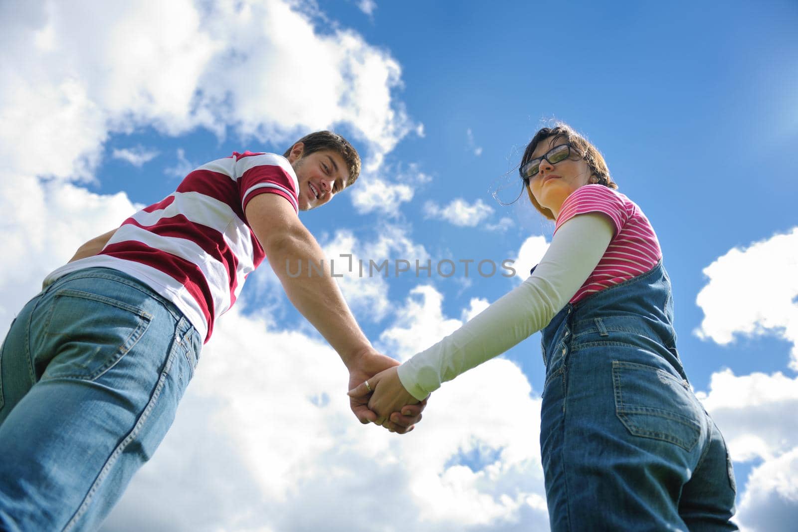 Portrait of romantic young couple in love  smiling together outdoor in nature with blue sky in background