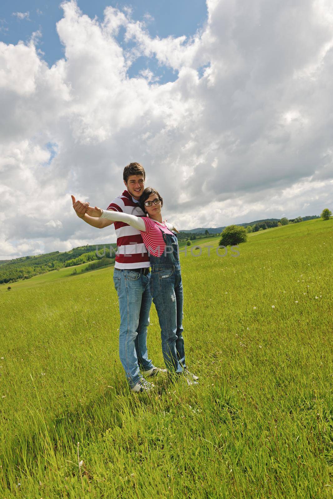 Portrait of romantic young couple in love  smiling together outdoor in nature with blue sky in background