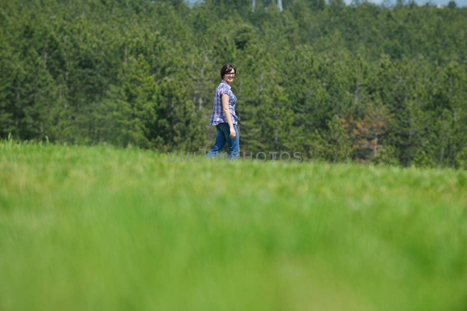 Enjoying the nature and life. Young woman arms raised enjoying the fresh air in green nature