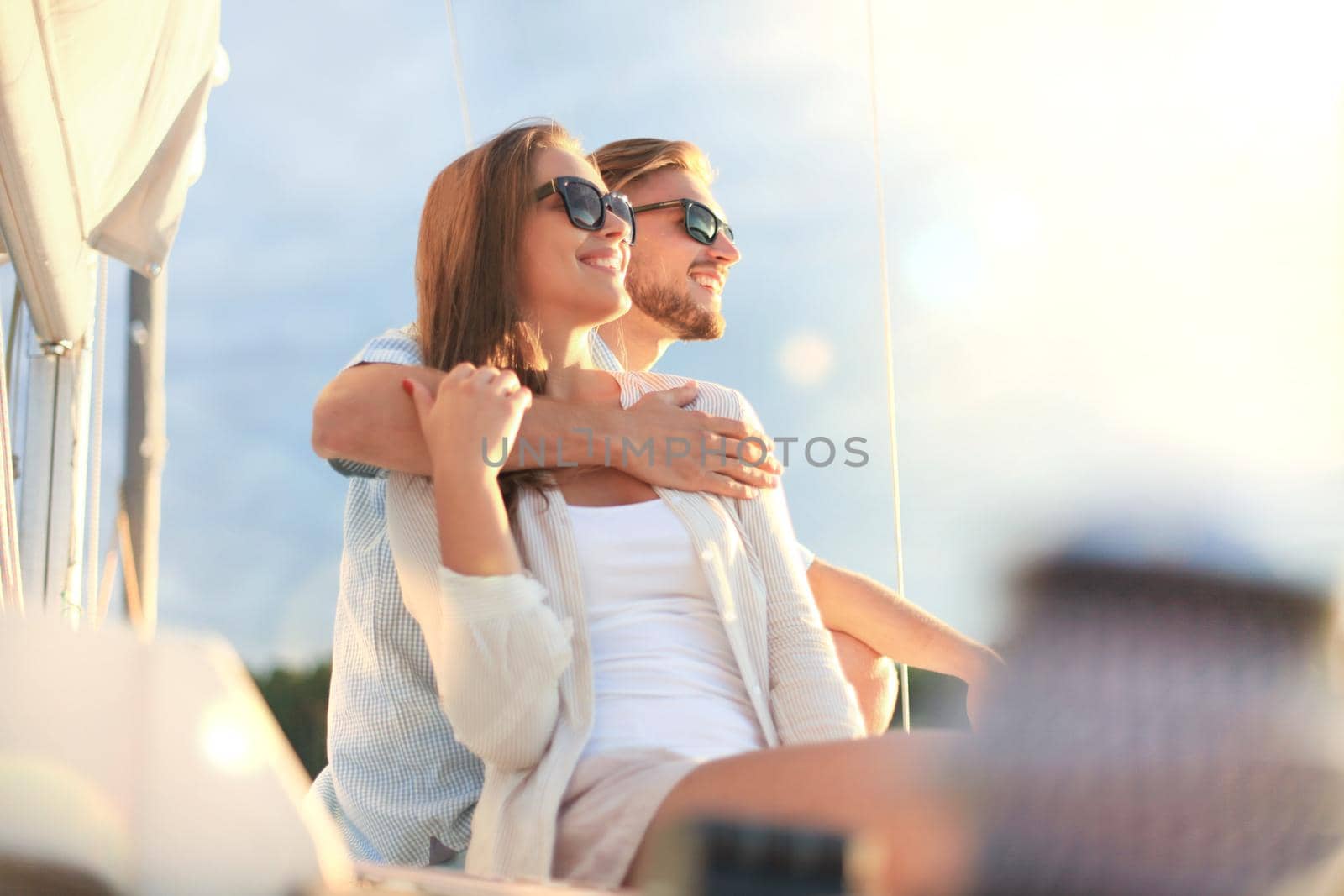 Attractive couple on a yacht enjoy bright sunny day on vacation.