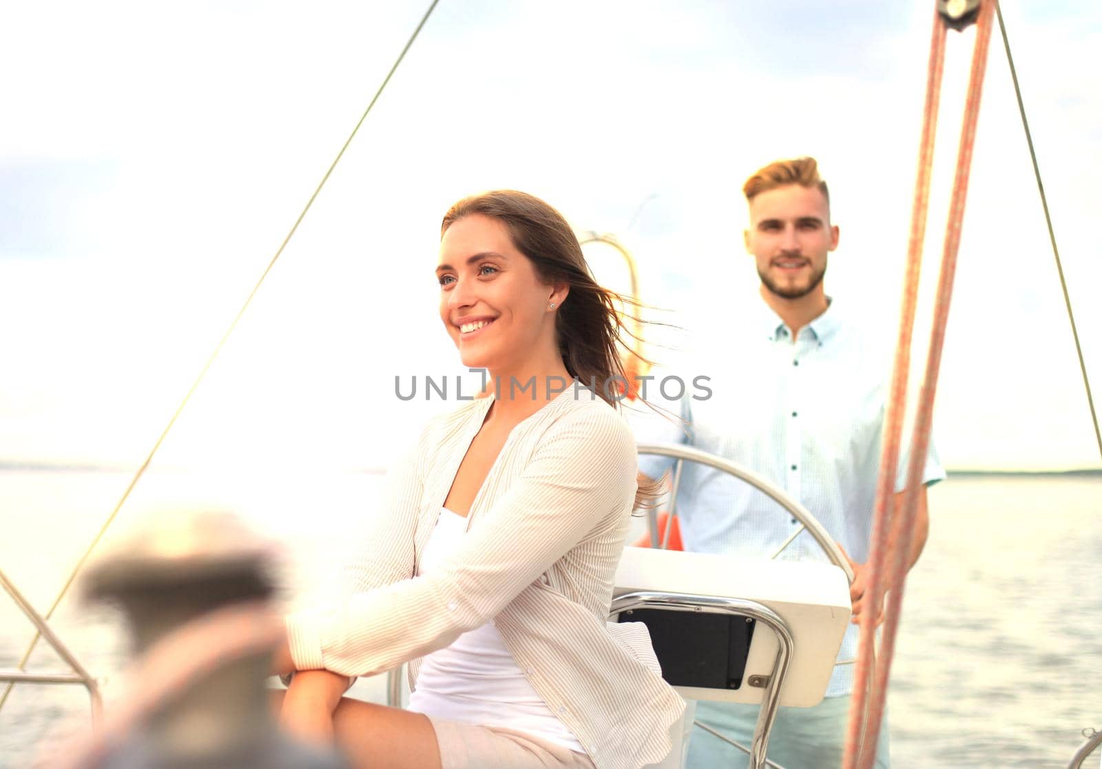 Attractive couple on a yacht enjoy bright sunny day on vacation.