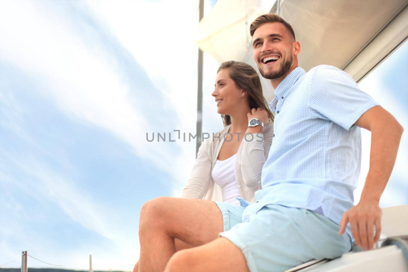 Attractive couple on a yacht enjoy bright sunny day on vacation.