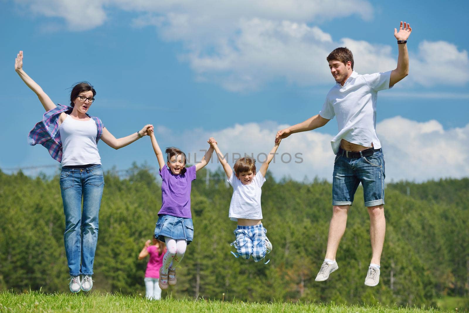 happy young family with their kids have fun and relax outdoors in nature with blue sky in background