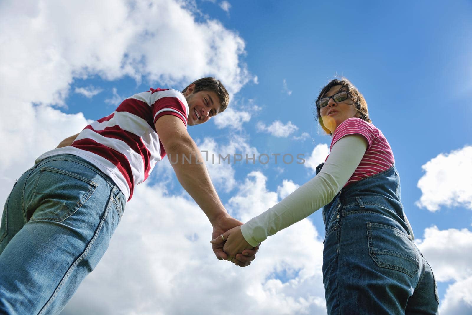 Portrait of romantic young couple in love  smiling together outdoor in nature with blue sky in background