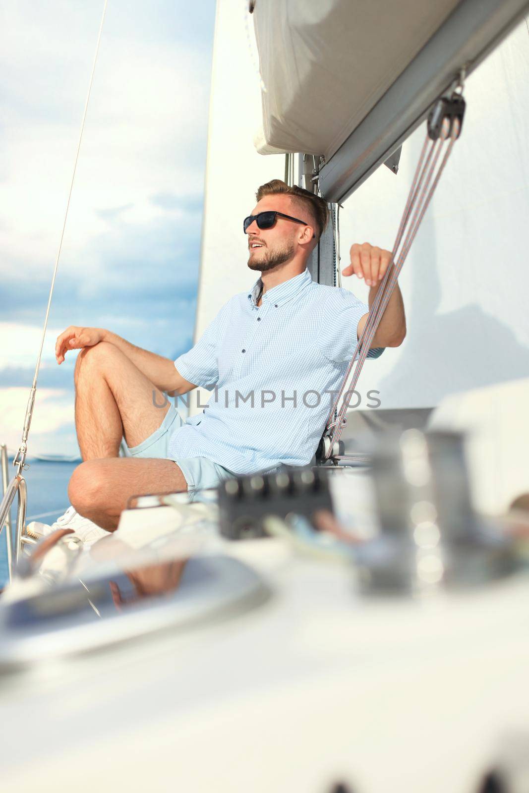 relaxing man sitting on boat sailing on sea happy and carefree. by tsyhun