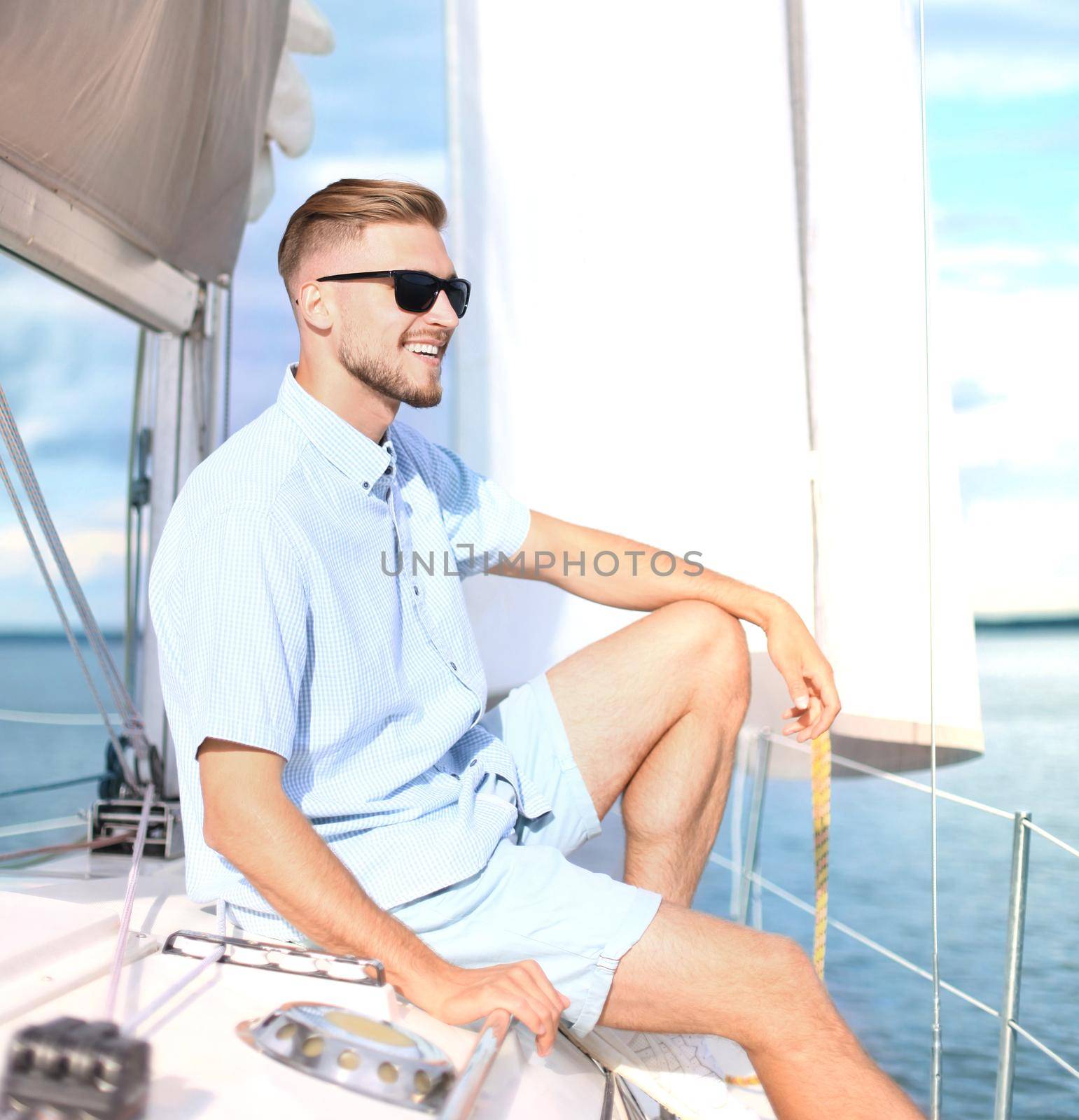 relaxing man sitting on boat sailing on sea happy and carefree. by tsyhun