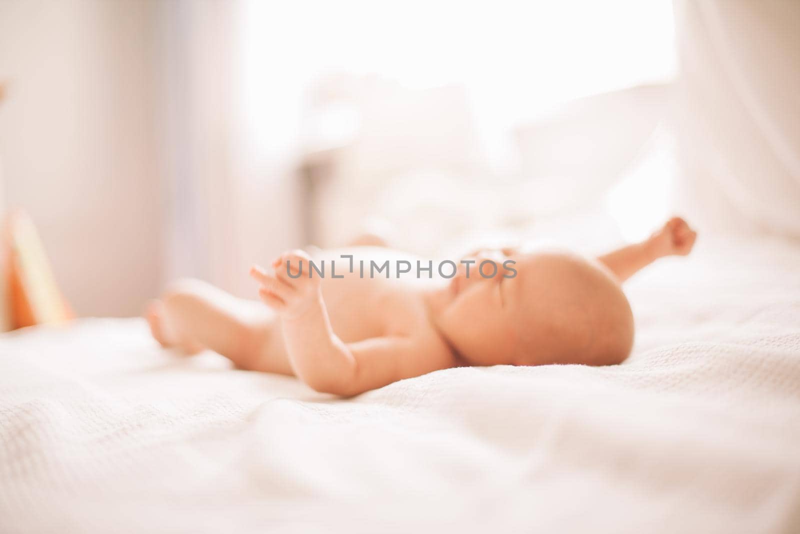 portrait of a pretty newborn baby lying on the bed